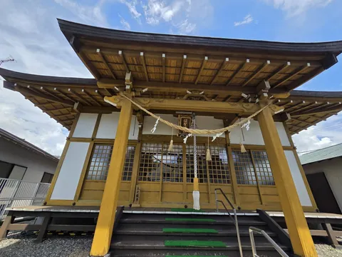 須賀神社：拝殿正面全景。太い注連縄と鰐口が下がり、朱色の柱と白壁の対比が際立つ。