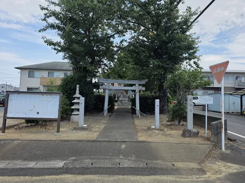 道路から見た境内の全景。左に地区の掲示板、右手前に社号標が立つ。