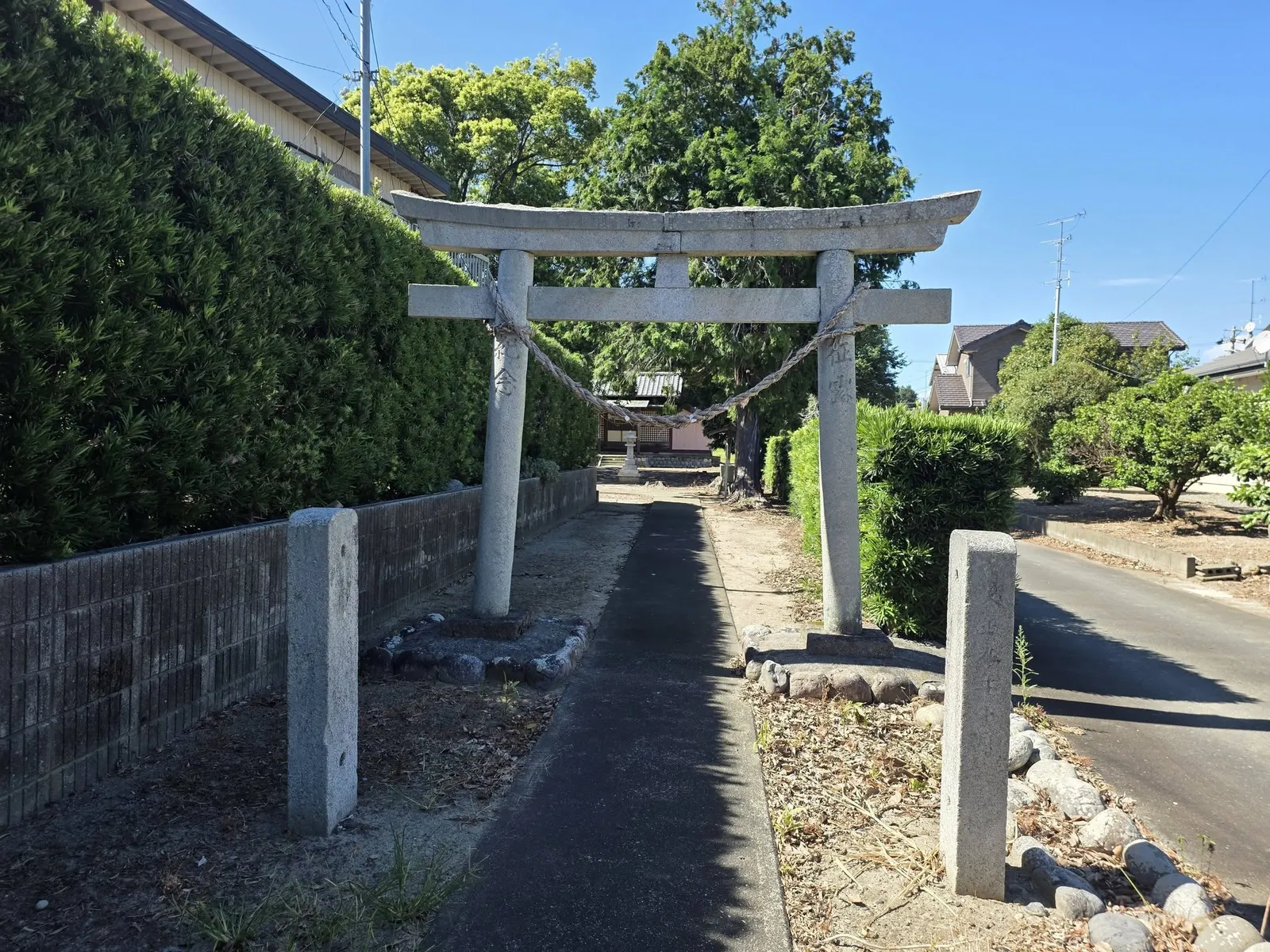 石造鳥居の正面から参道と社殿を望む。