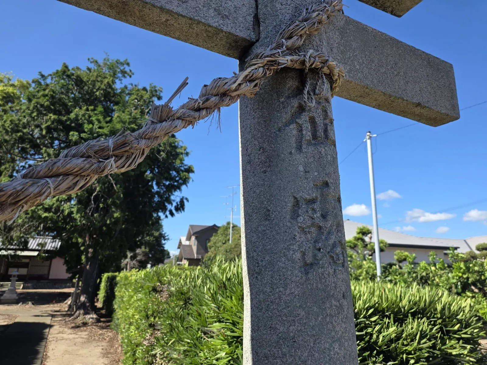 注連縄を掛けた石造鳥居の柱と刻銘。