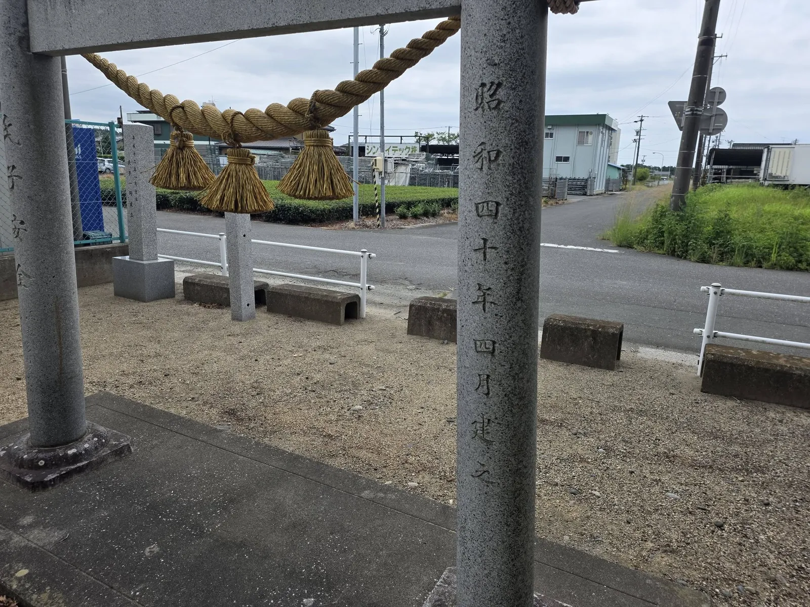 注連縄を掛けた石造鳥居と柱の奉納銘。