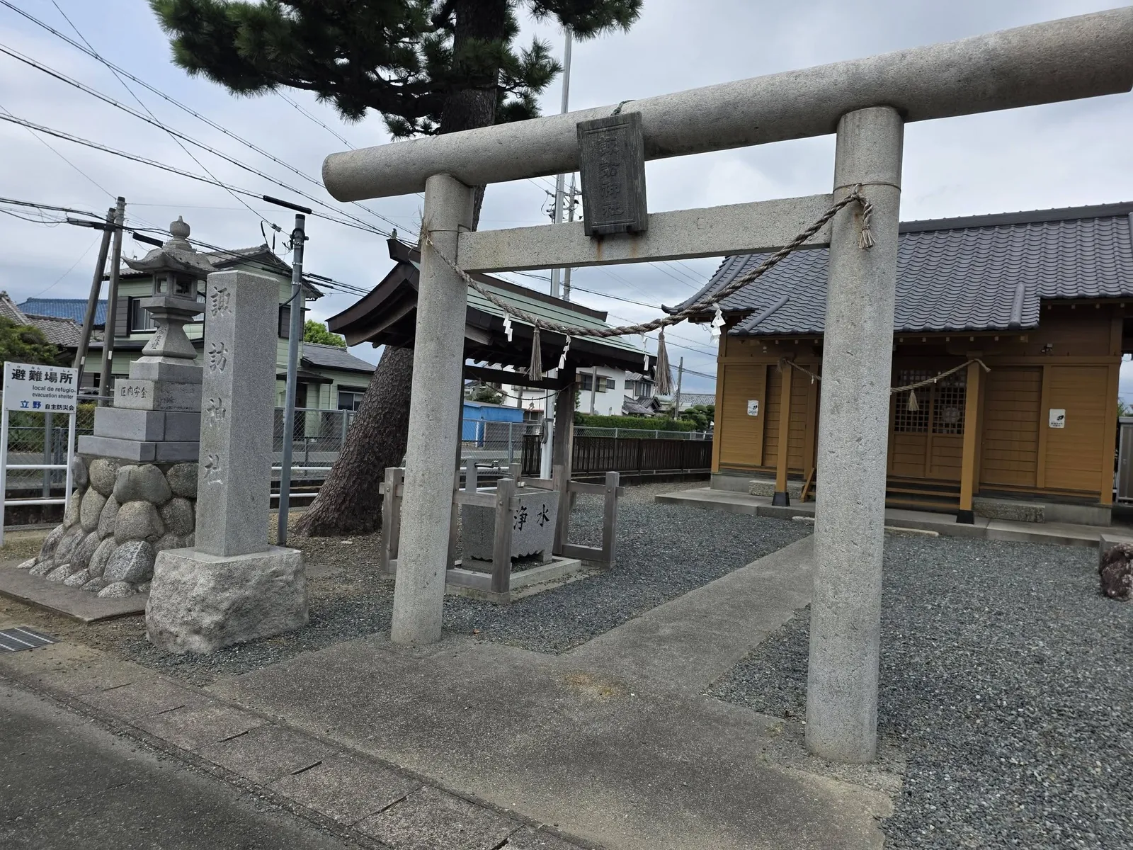 道路側から斜めに見た石造鳥居と社殿。