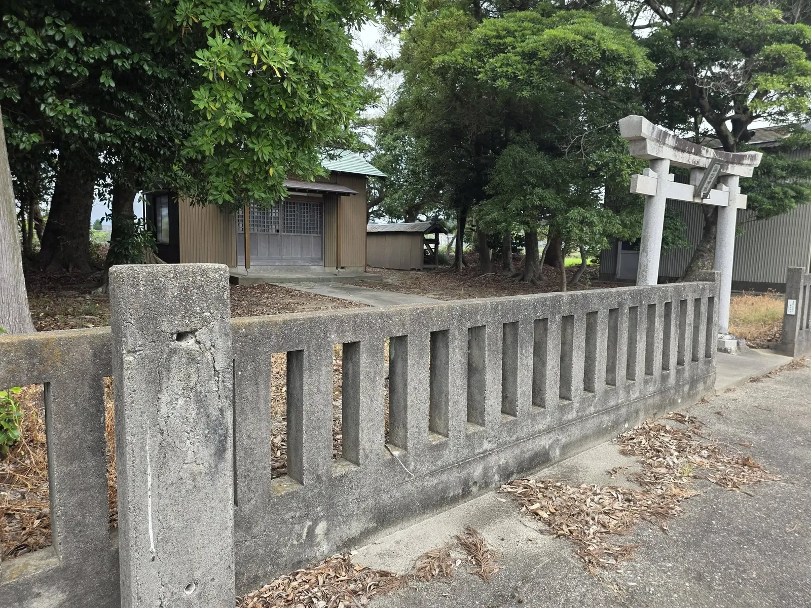 道路側から見た玉垣、石造鳥居と境内。