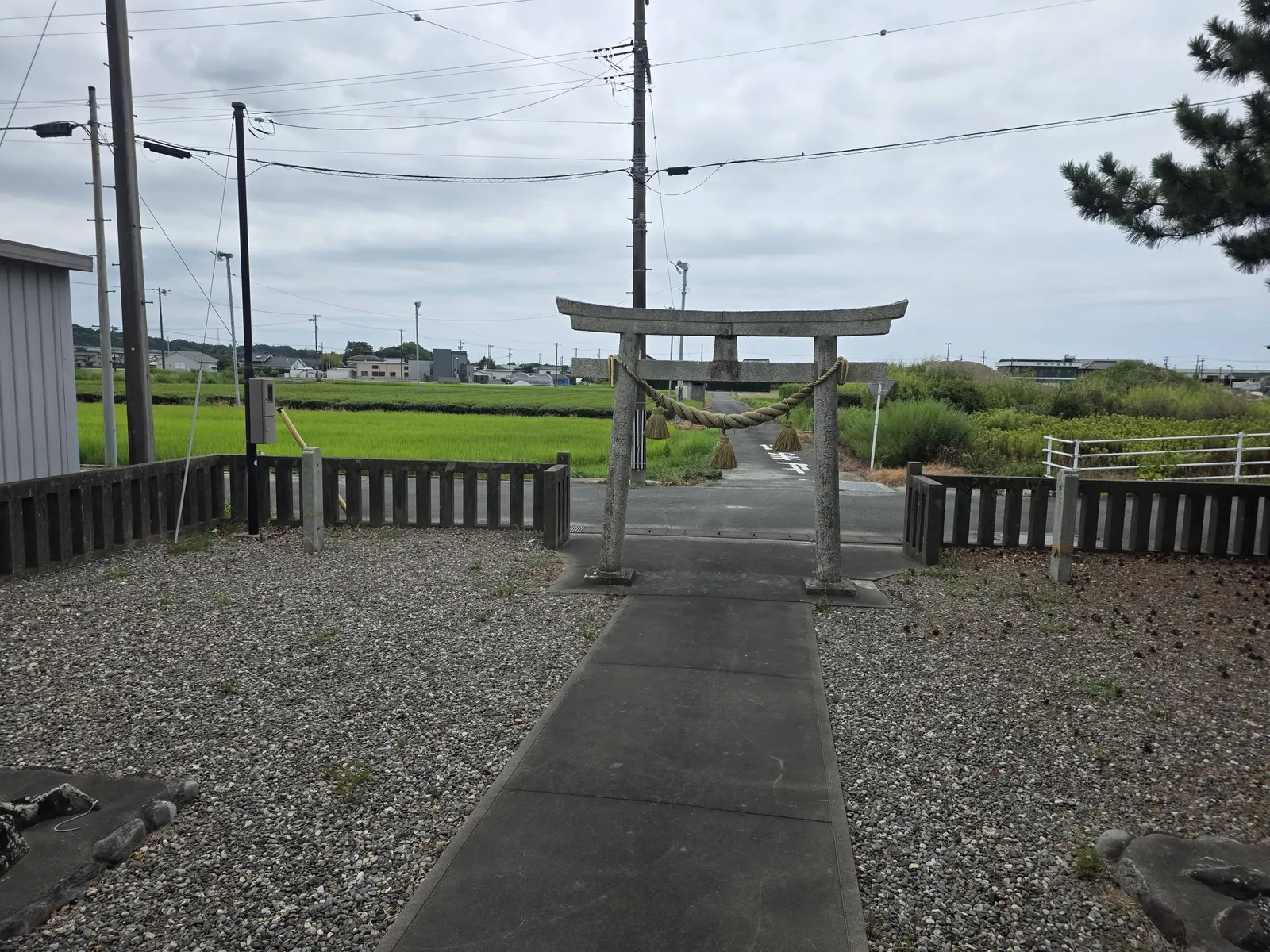 社殿側から石造鳥居と田園に面した参道を望む。