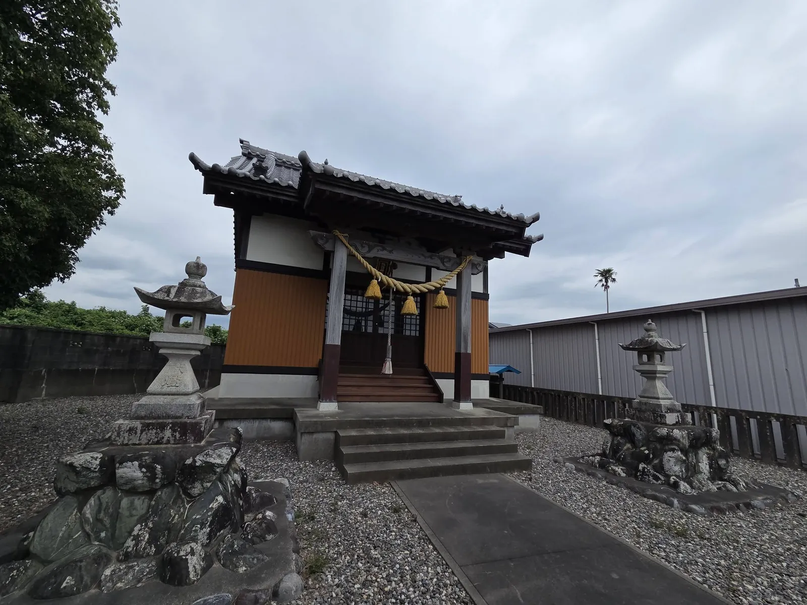 斜めから見た諏訪神社の社殿と石灯籠。