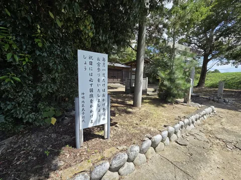 「おかげ参りをいたしましょう」と記す神明地区氏子総代の掲示板。奥に鳥居と社殿が見える。