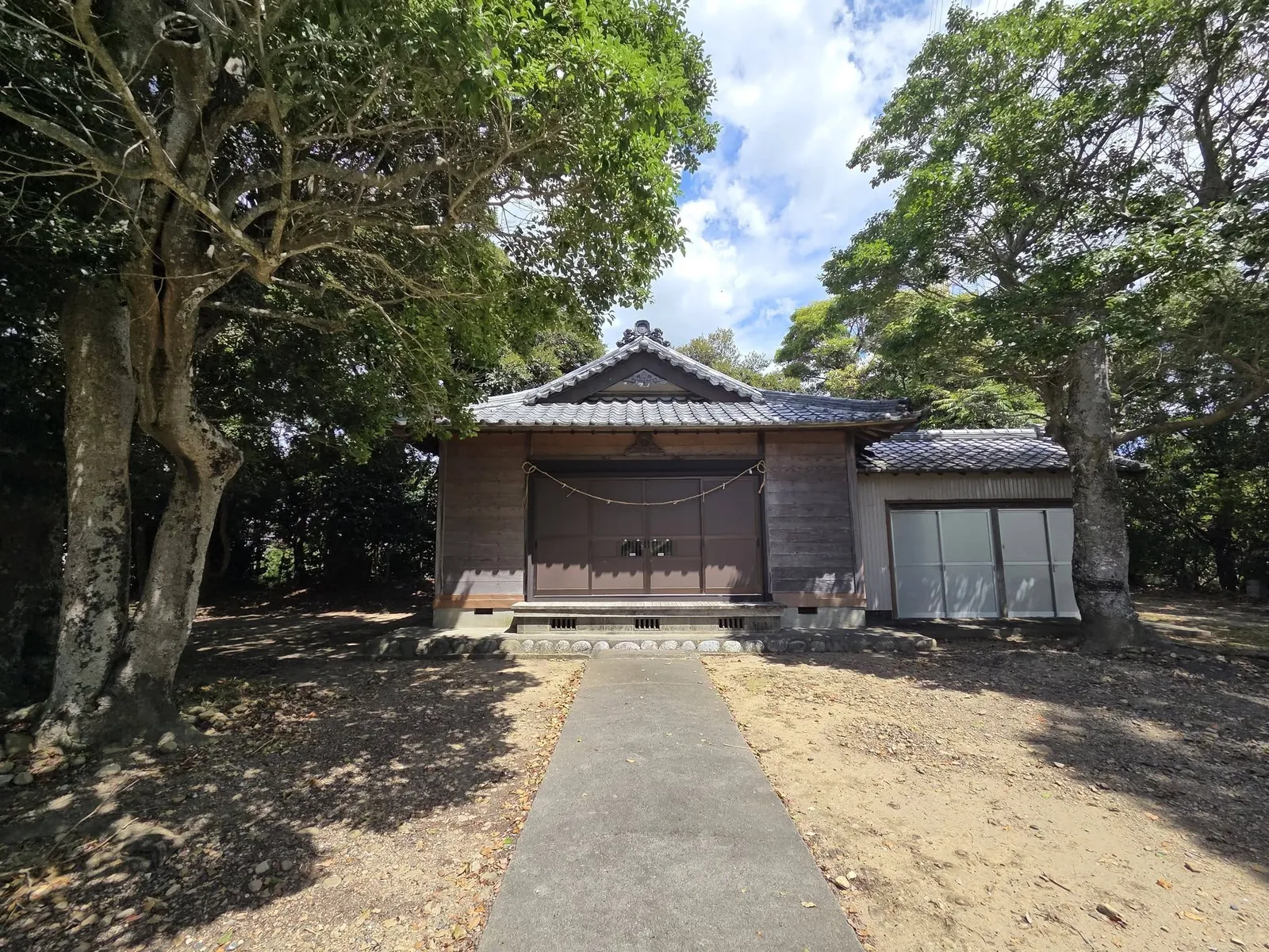 正面から見た社殿。板戸に注連縄を掛け、切妻屋根の破風に懸魚を施す。