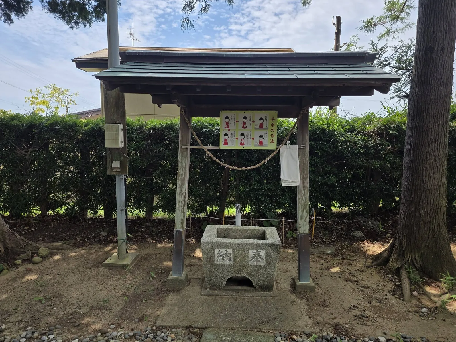 境内の手水舎。参拝作法の案内を掲げ、石造の水盤を備える。