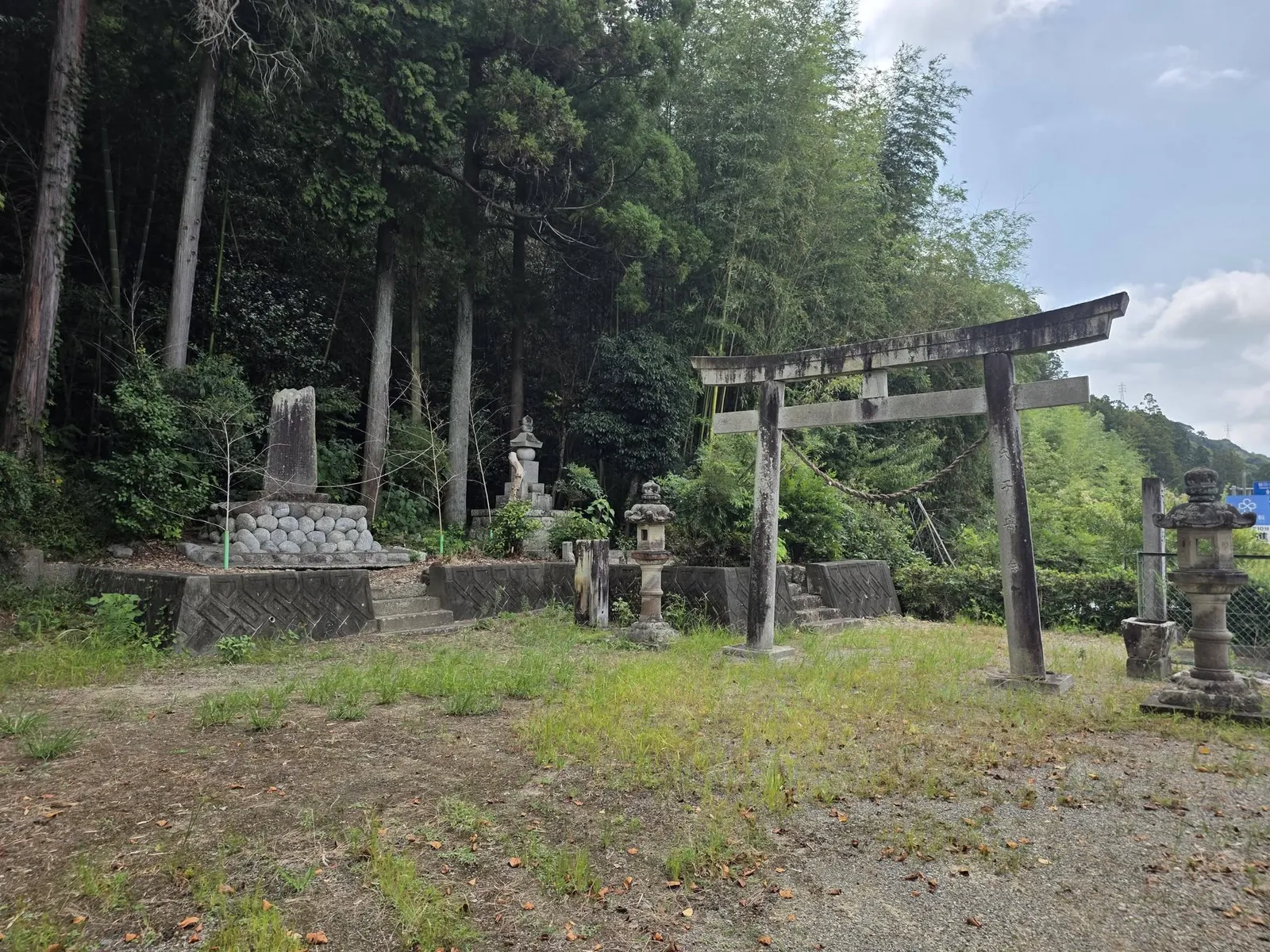 石碑・石灯籠と石造鳥居が並ぶ境内入口。