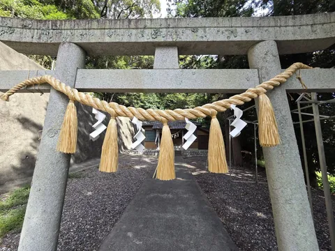鳥居に掛けられた注連縄と紙垂。奥に社殿を望む。