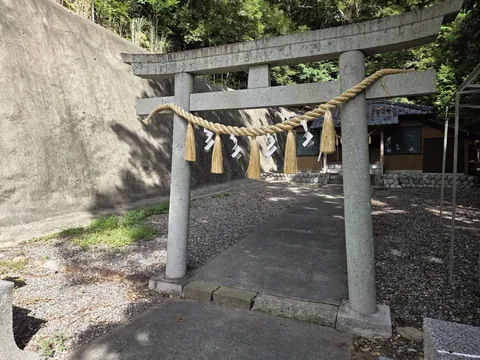 鳥居正面。注連縄の奥に社殿と隣接する建物が見える。