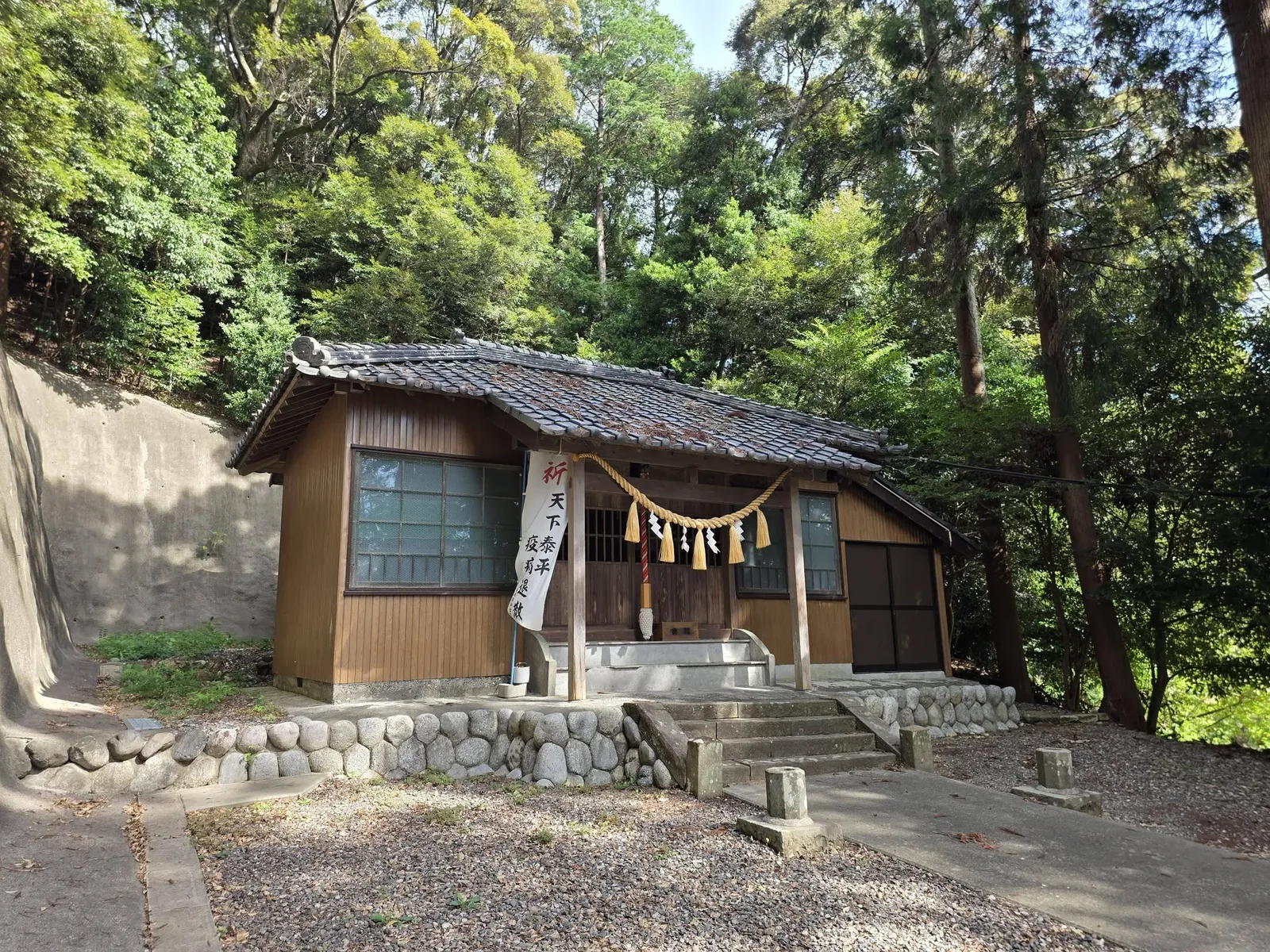 斜め前方から見た社殿。「祈 天下泰平 疫病退散」と書かれた幟旗を立てる。