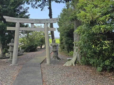 境内側から石造鳥居と参道、その先の田園を望む。
