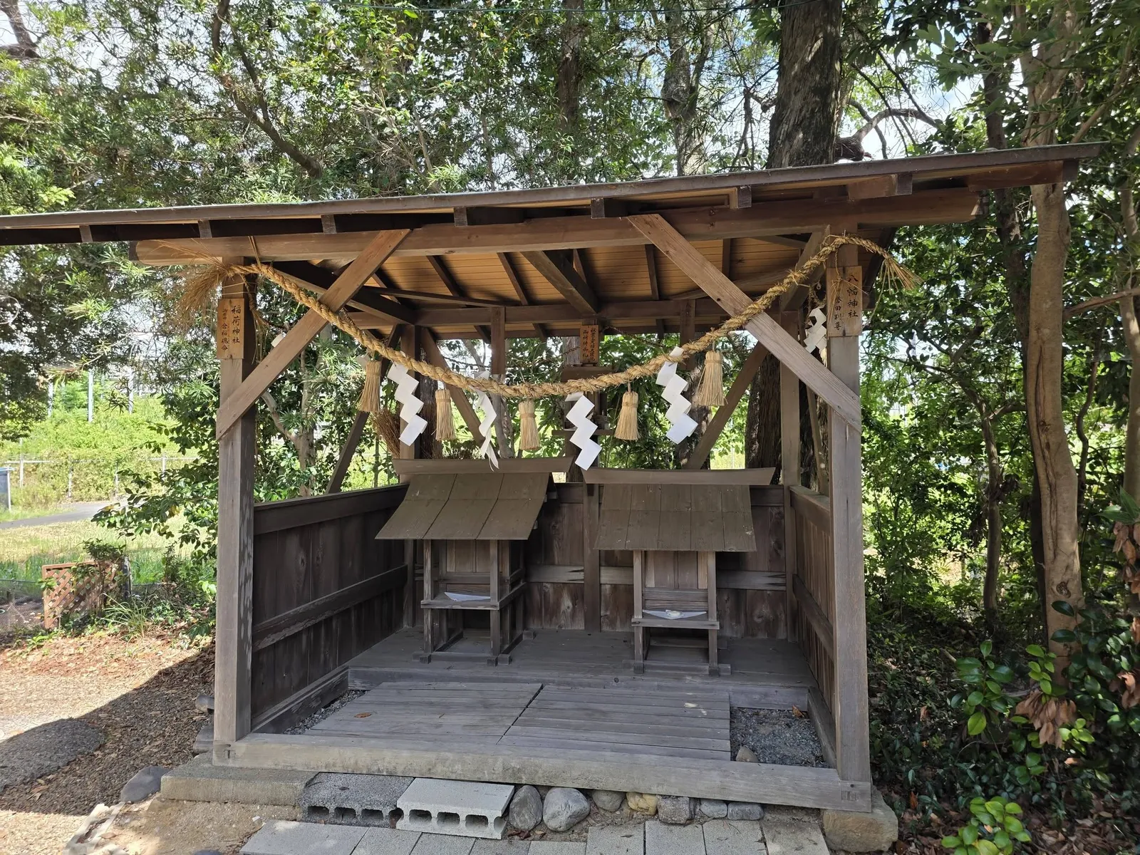 境内社の覆屋。「稲荷神社」「八幡神社」の額を掲げた二社が並んで祀られている。