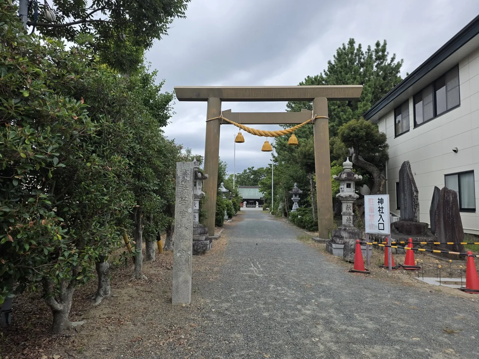 注連縄を掛けた石造鳥居と参道。