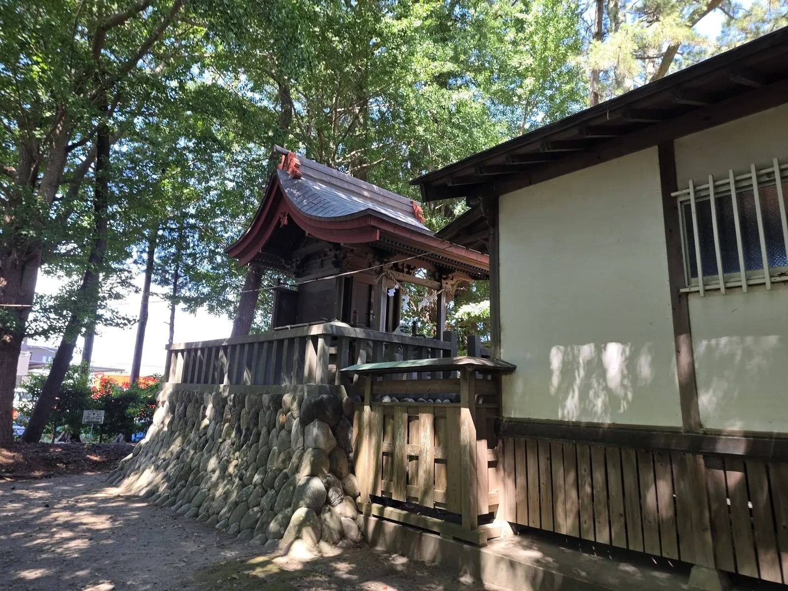朱塗りの屋根を備えた境内社の側面。