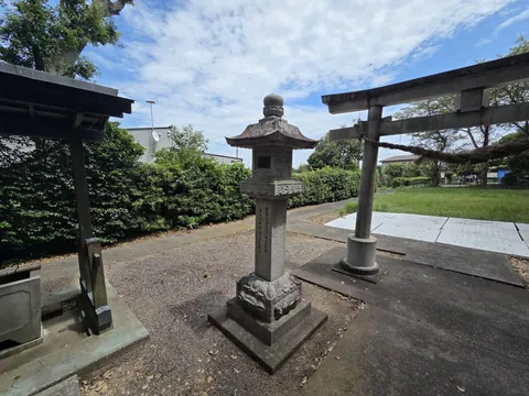 境内の石灯籠と石造鳥居。左手に手水舎が見える。