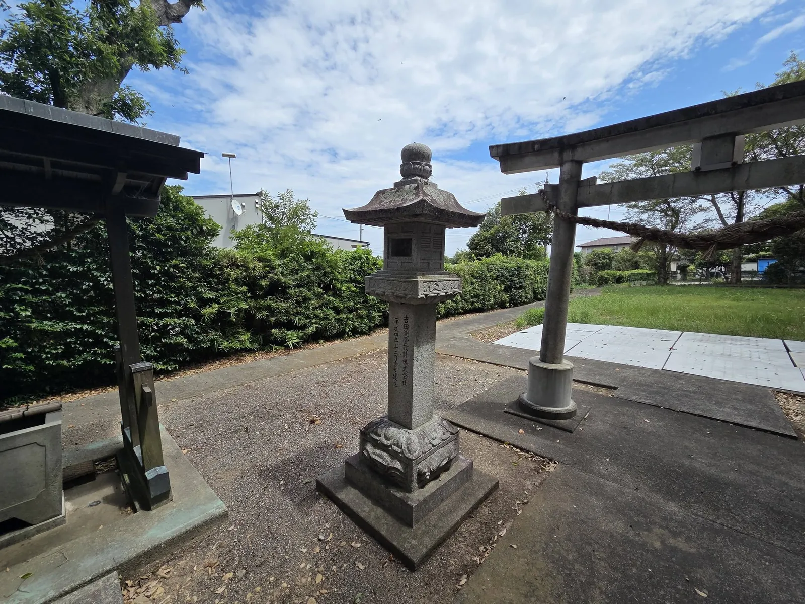 境内の石灯籠と石造鳥居。左手に手水舎が見える。