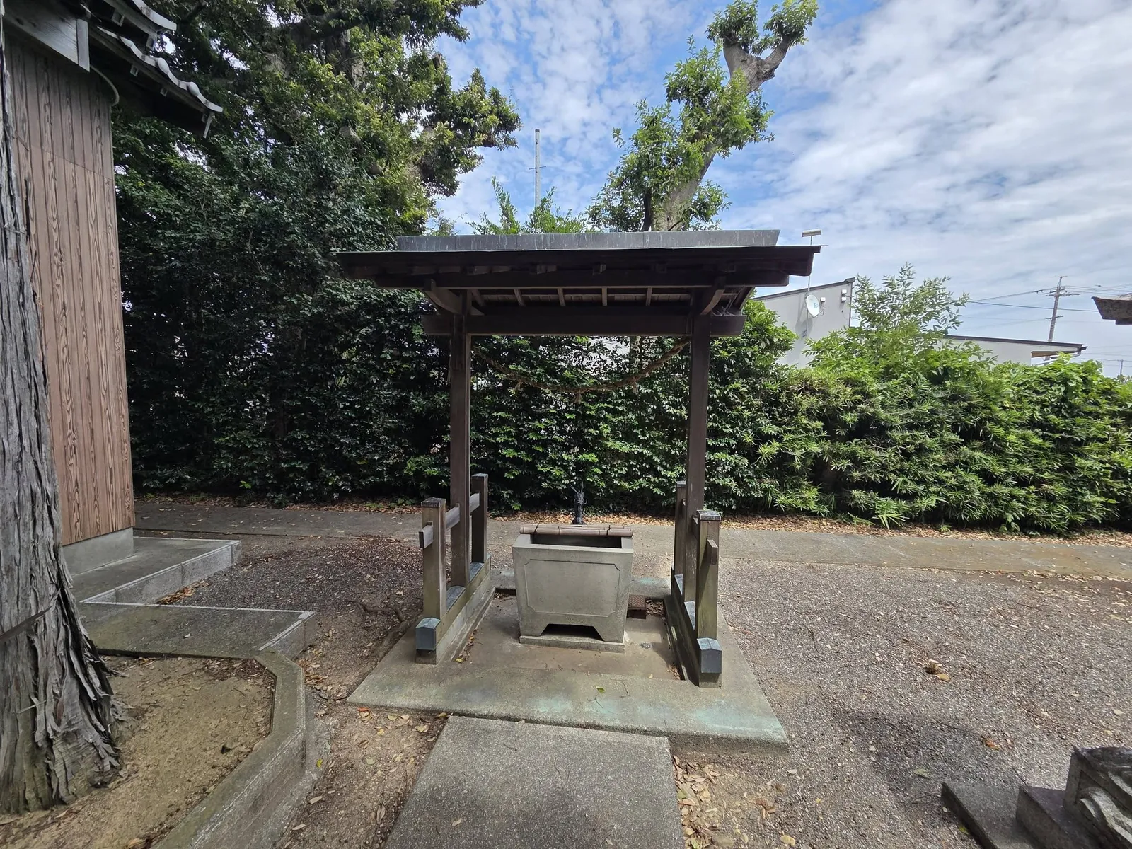 社殿脇の手水舎。石造の水盤を備える。