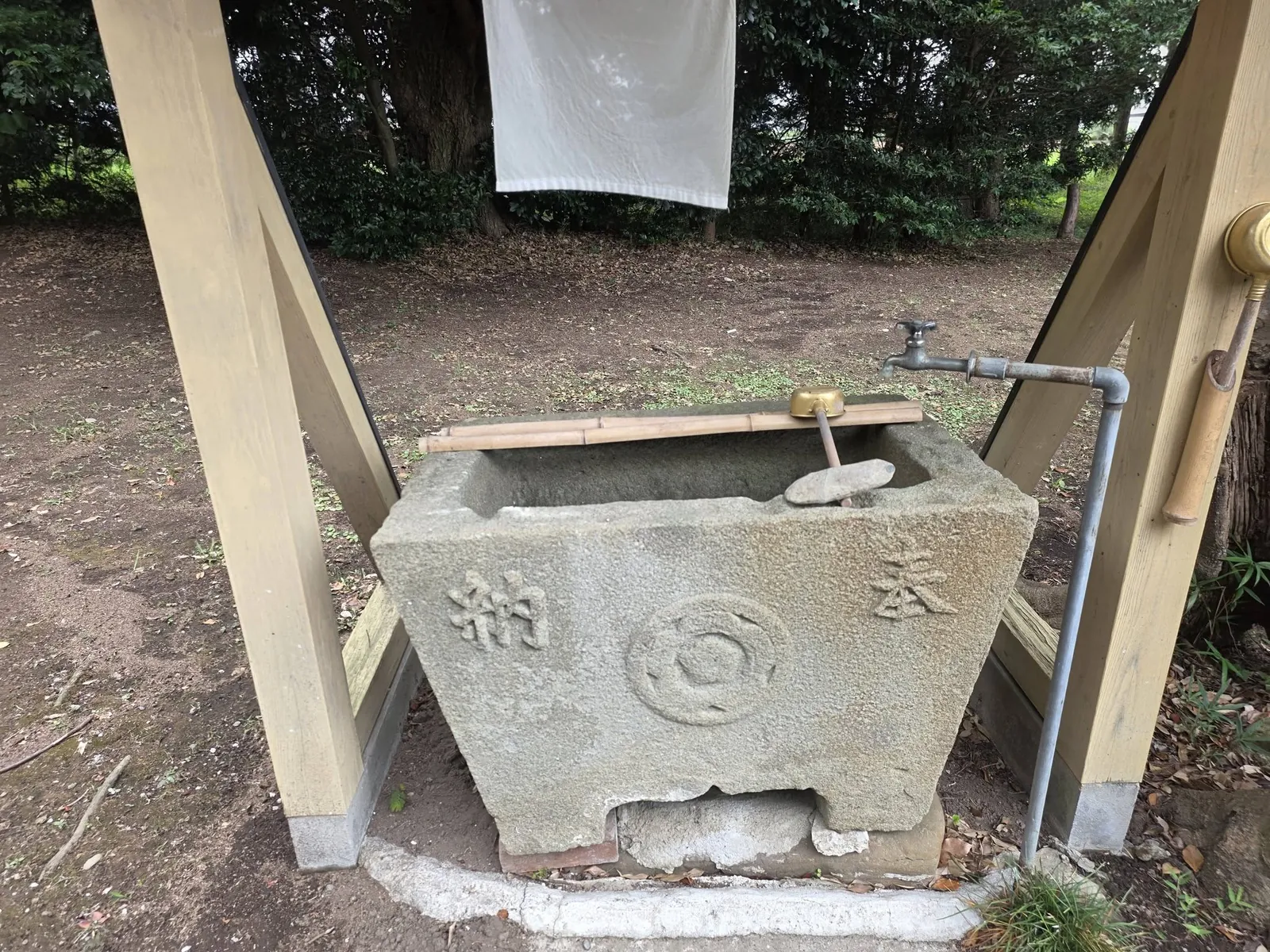 手水鉢の近景。正面に神紋と「奉納」の文字を刻む。