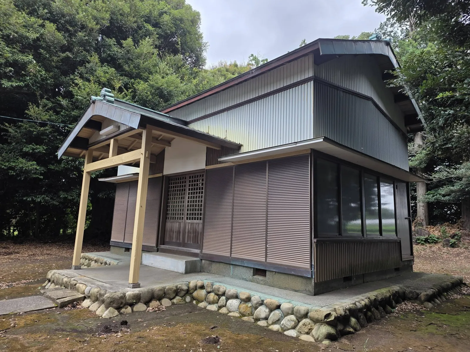 社殿を斜め前から見る。向拝と側面の外壁が分かる。