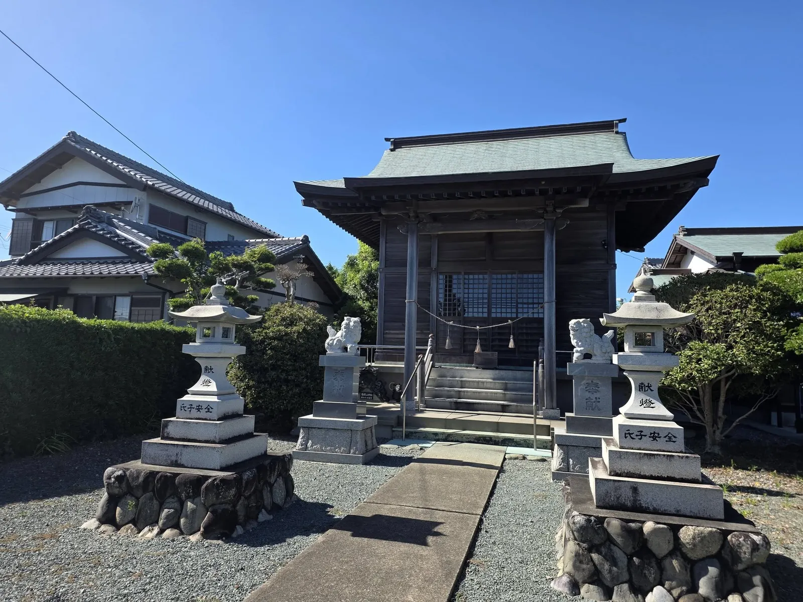石灯籠と狛犬が並ぶ社殿正面。