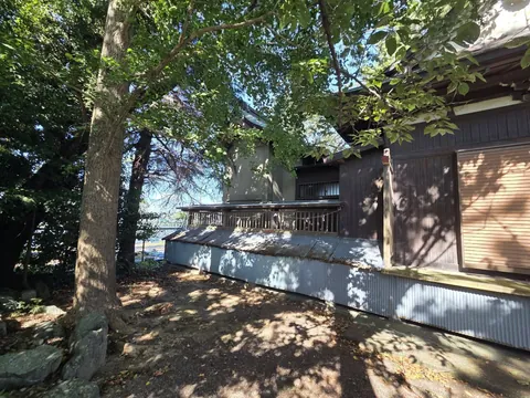 木立の中に建つ藏王神社の社殿を側方から見る。