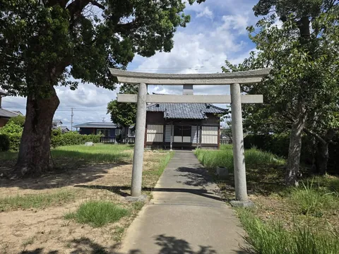 参道正面から見た石造鳥居。奥に社殿が見える。